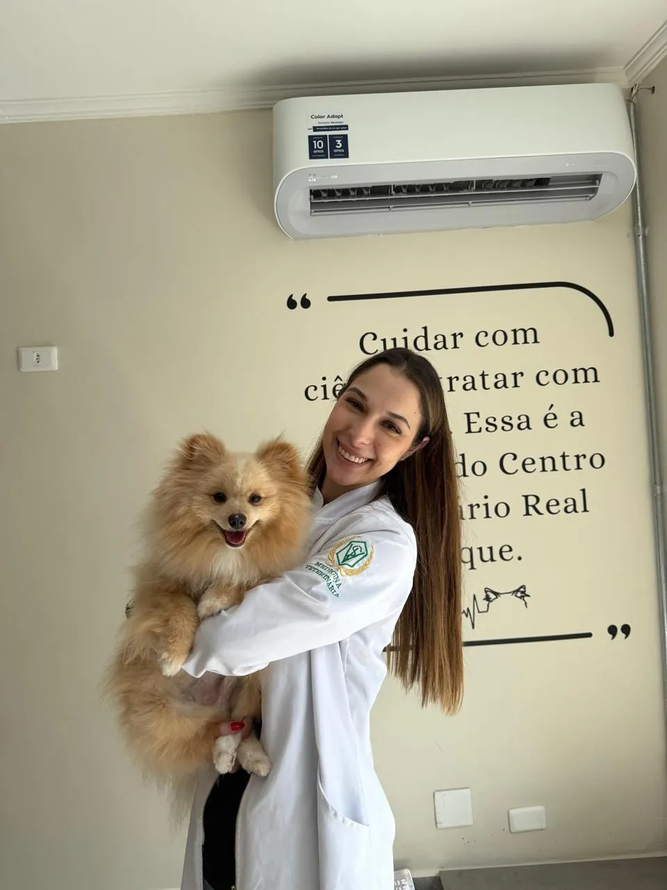 Veterinária de jaleco com um spitz alemão no colo